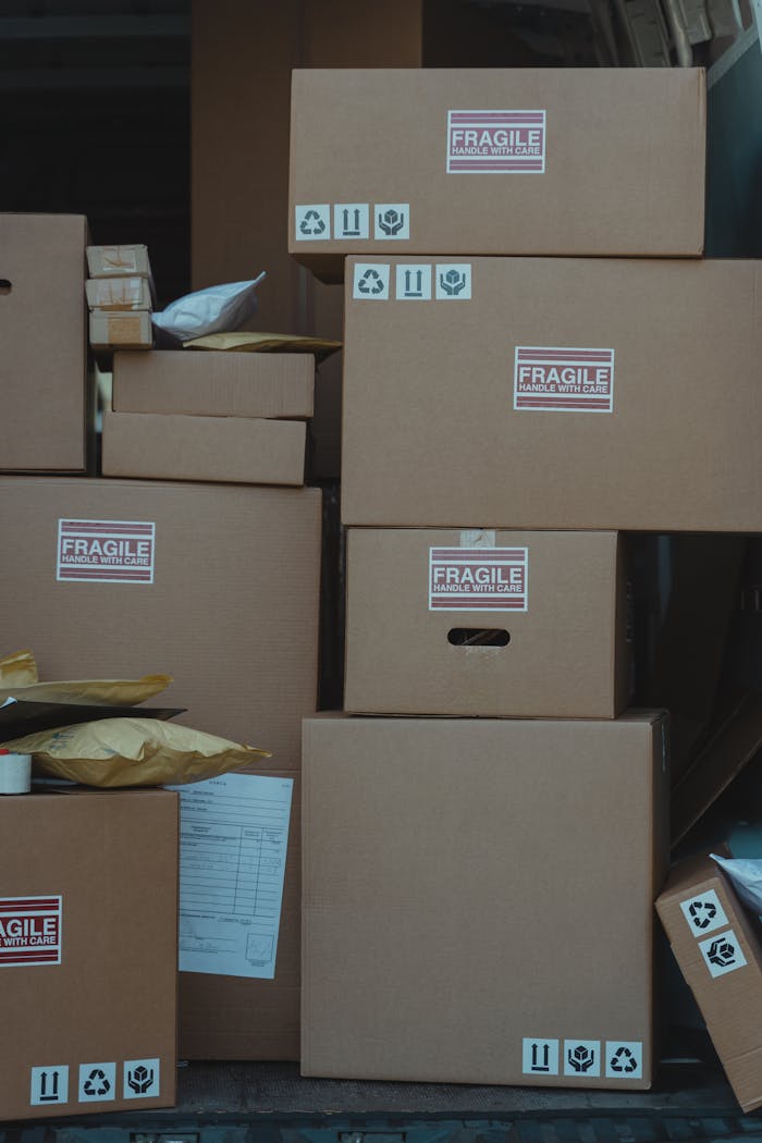 Vertical stack of cardboard boxes labeled fragile for shipping and storage.