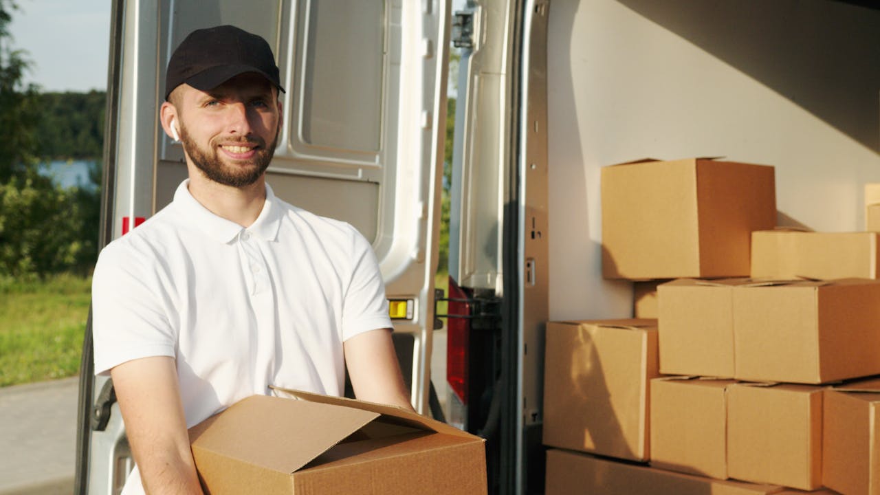 creative Courier managing deliveries with a panel van, holding boxes outside.